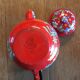Red enamel teapot with hand-painted floral decoration