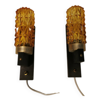 A set of Danish wall lamps, in amber coloured glass with a hard pressed black plastic base.