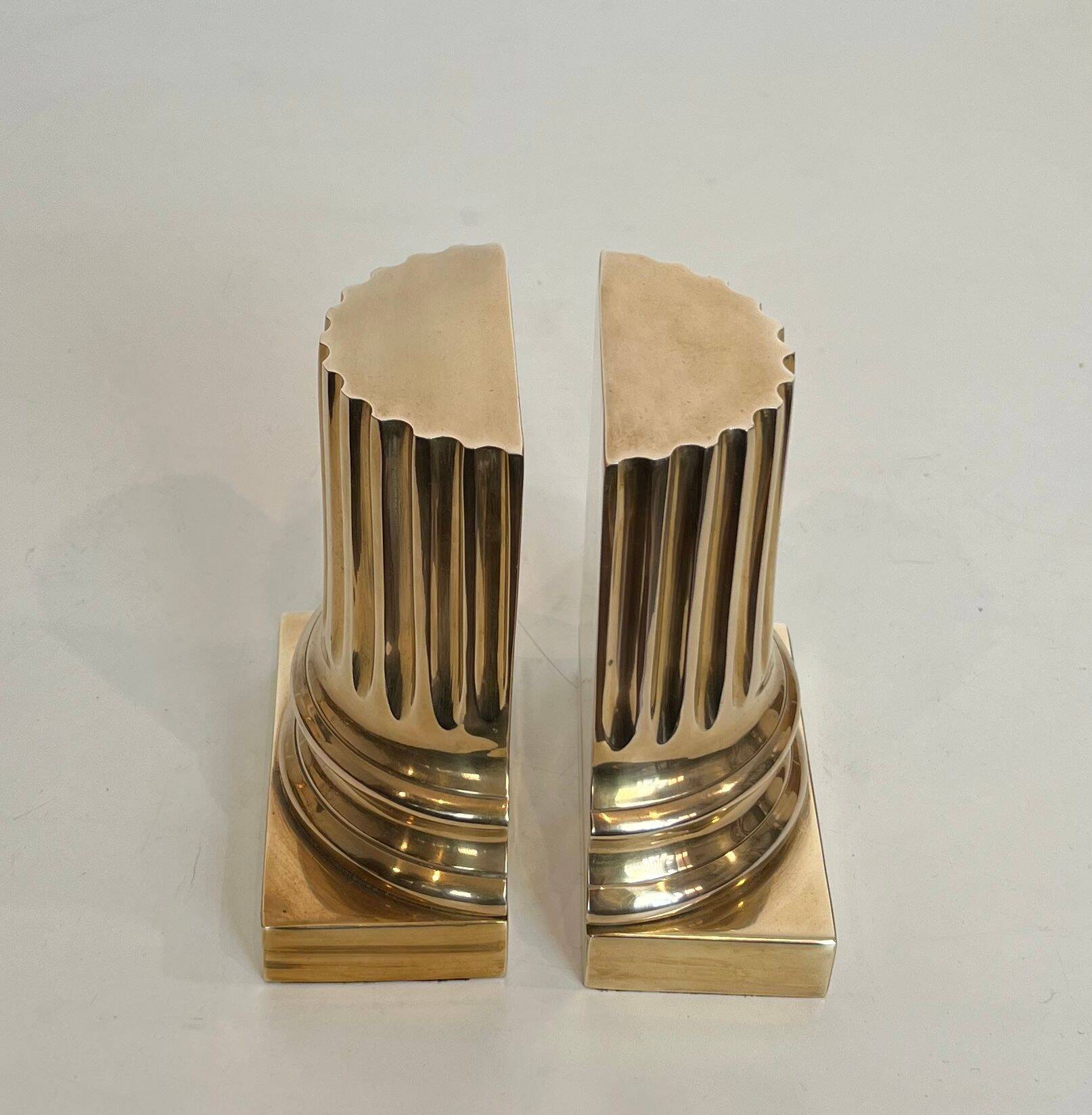 A pair of brass bookends representing columns.