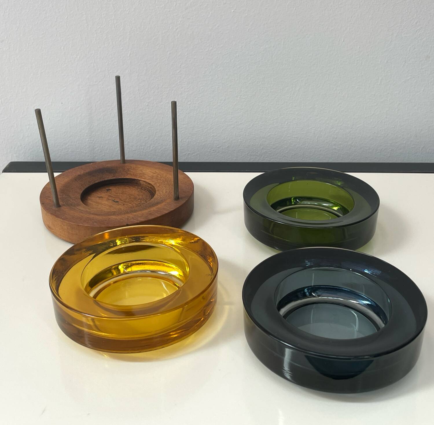 Set of 3 stackable glass catchalls with a teak base.