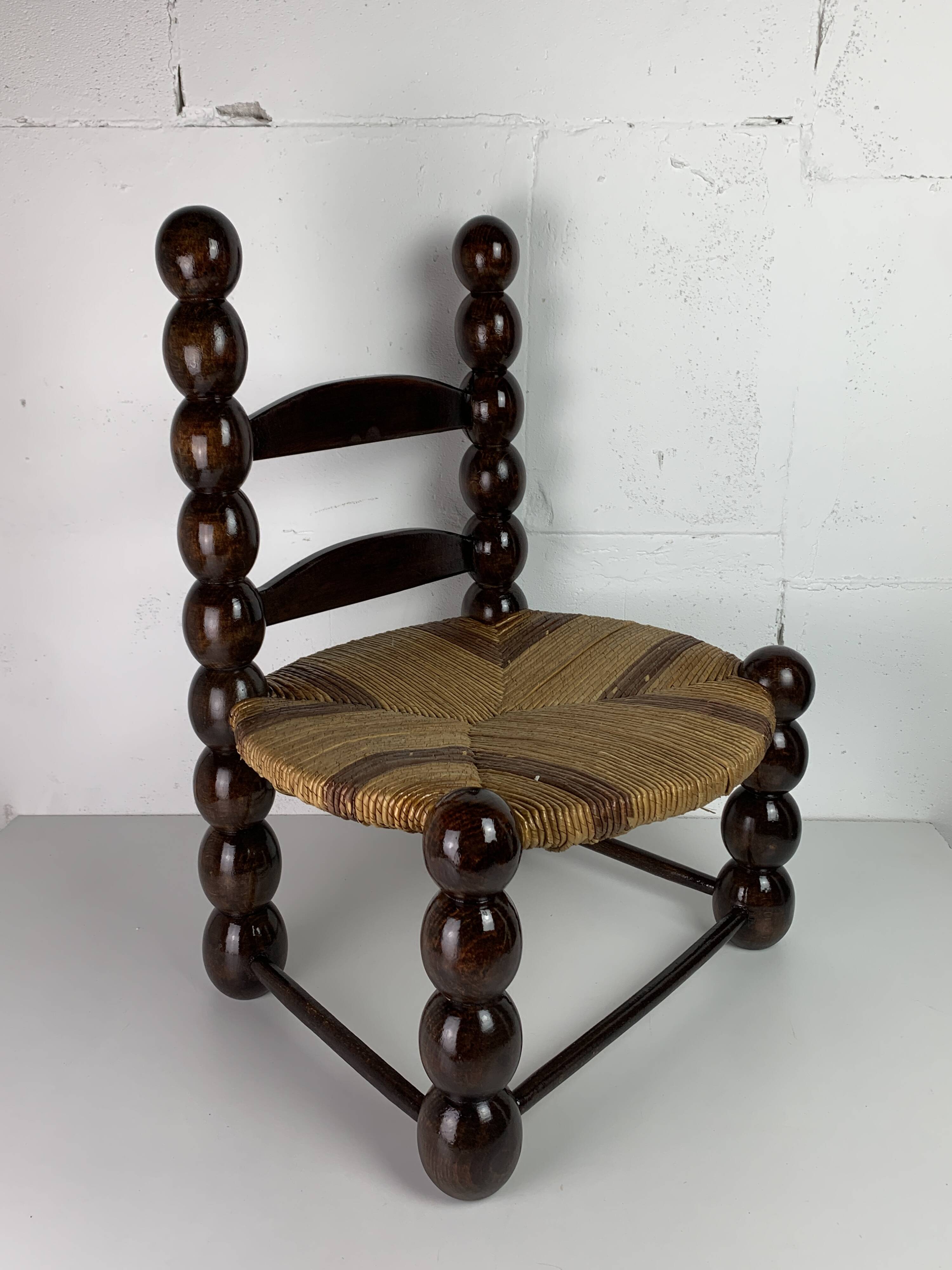 Brutalist wood turned bobbin low rush chair n the style of Charles Dudouyt