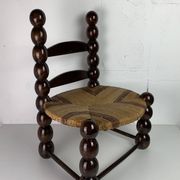 Brutalist wood turned bobbin low rush chair n the style of Charles Dudouyt