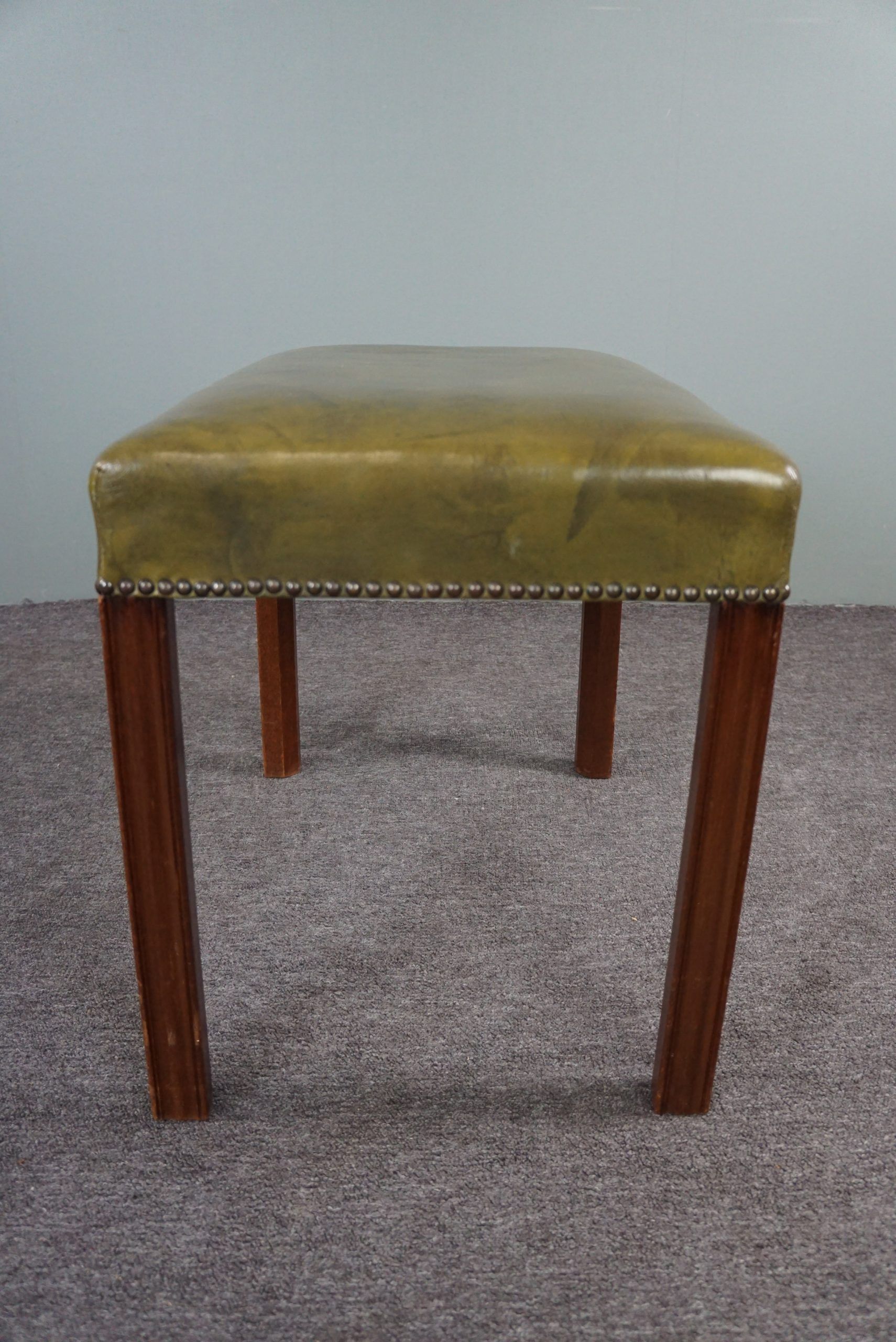 Elegant armchair and footrest in English green leather