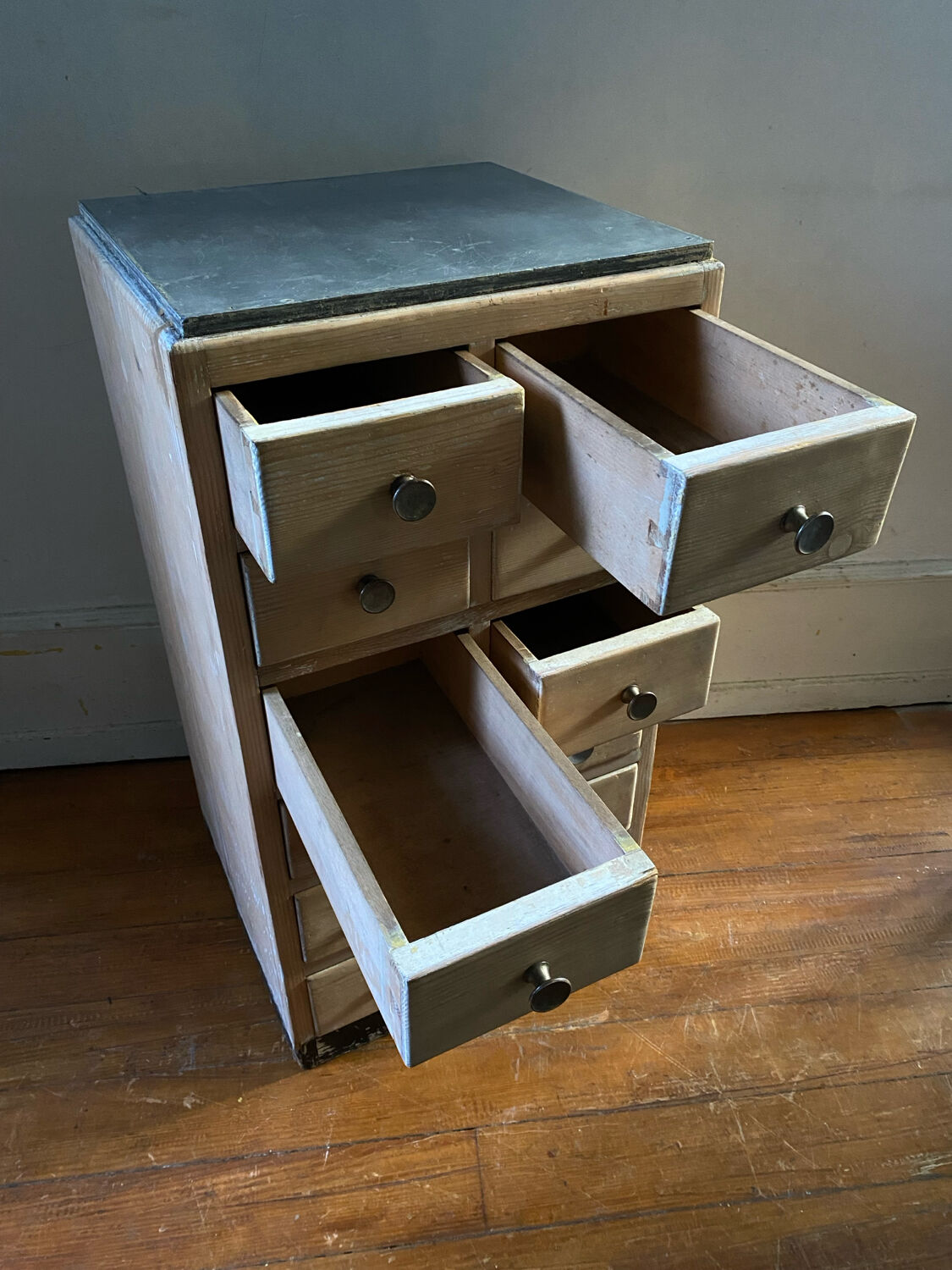 Vintage antique workshop cabinet with 12 drawers in raw wood.