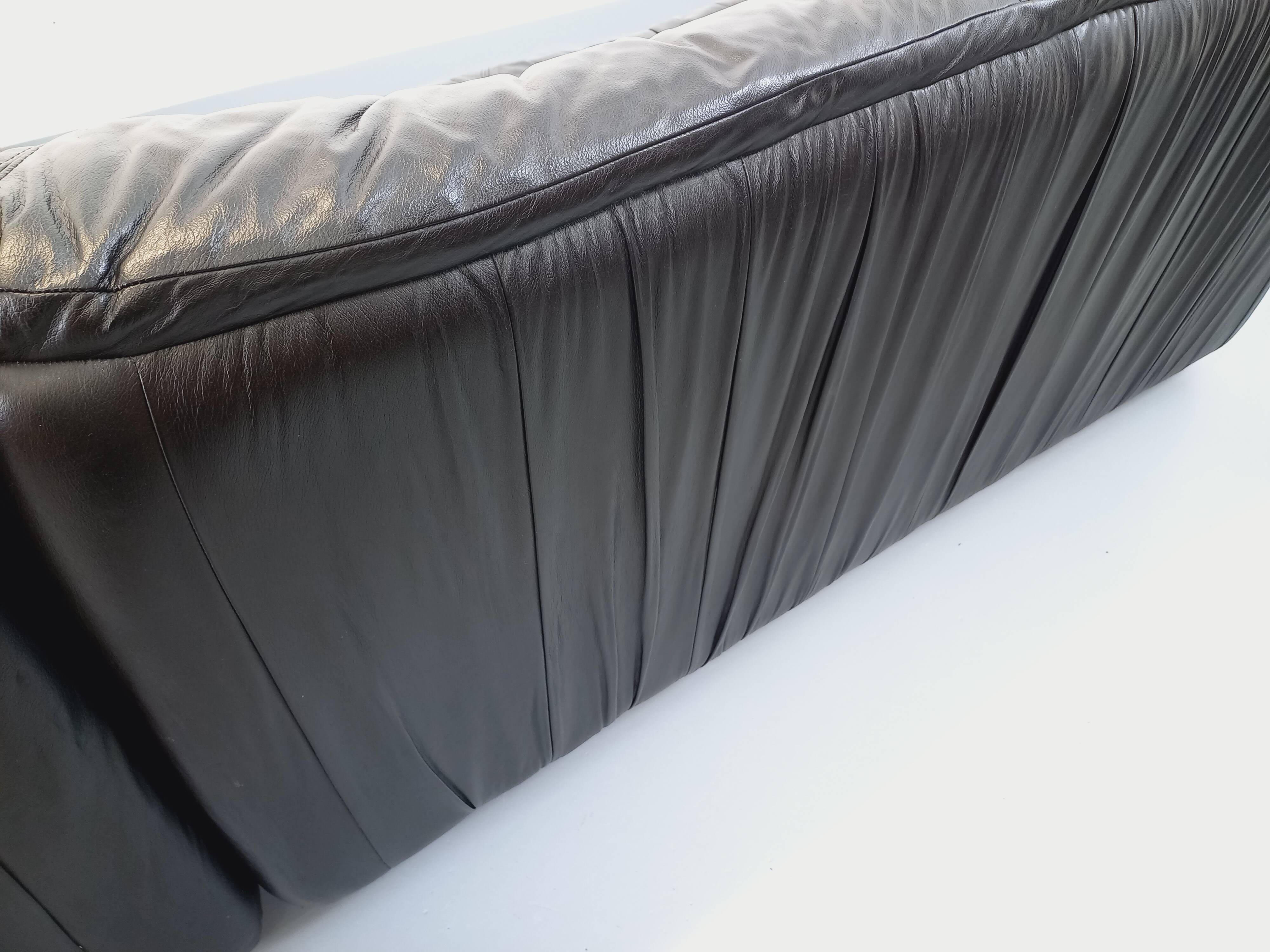 Vintage corner sofa composed of 3 modules in black leather with integrated bed.