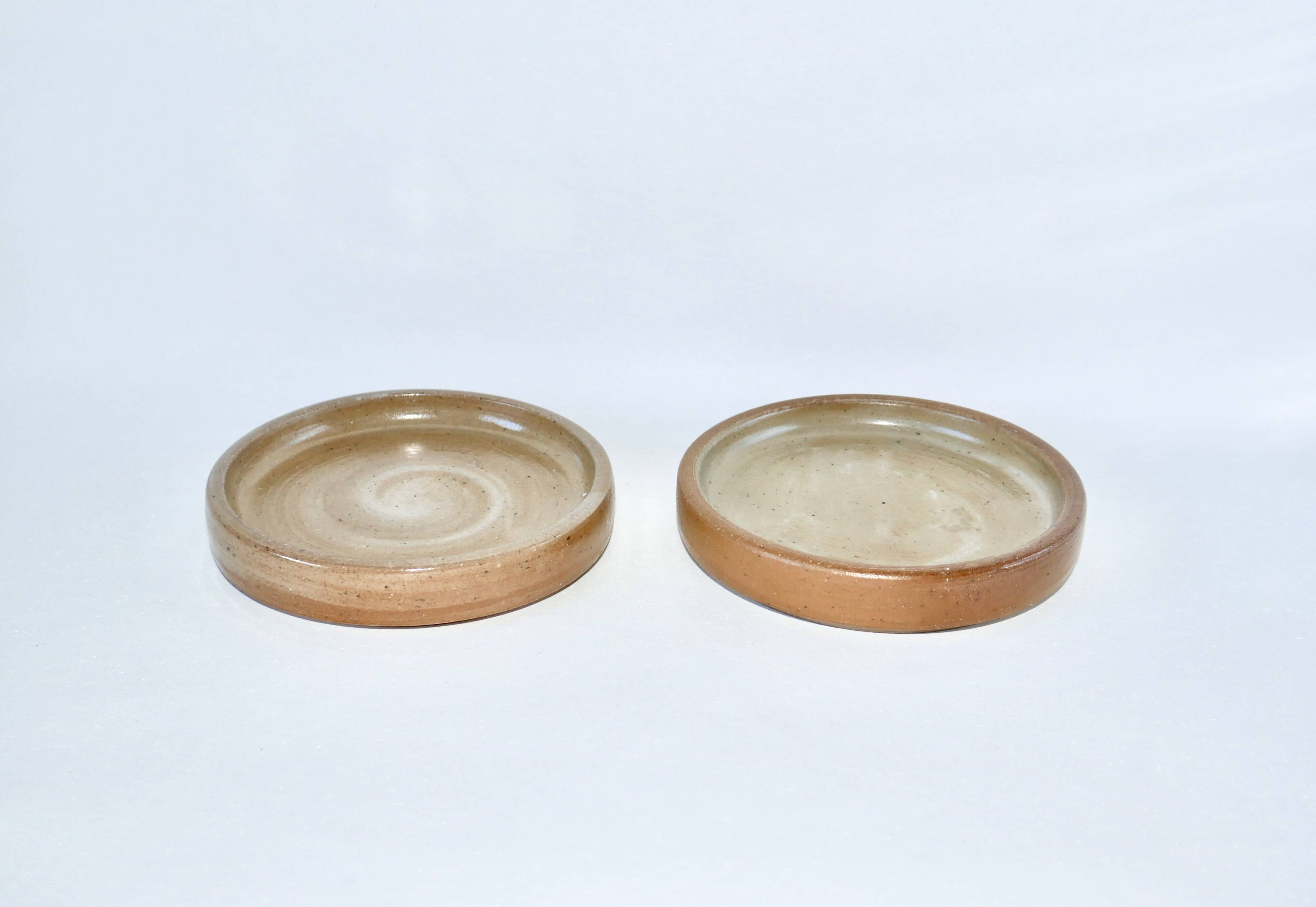 Pair of enamelled stoneware bottle coasters 1970
