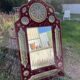 Large oriental mirror with embossed brass decoration on a red velvet background
