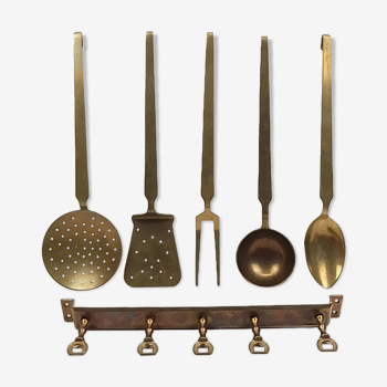5 kitchen utensils and a brass wall mount