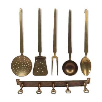 5 kitchen utensils and a brass wall mount