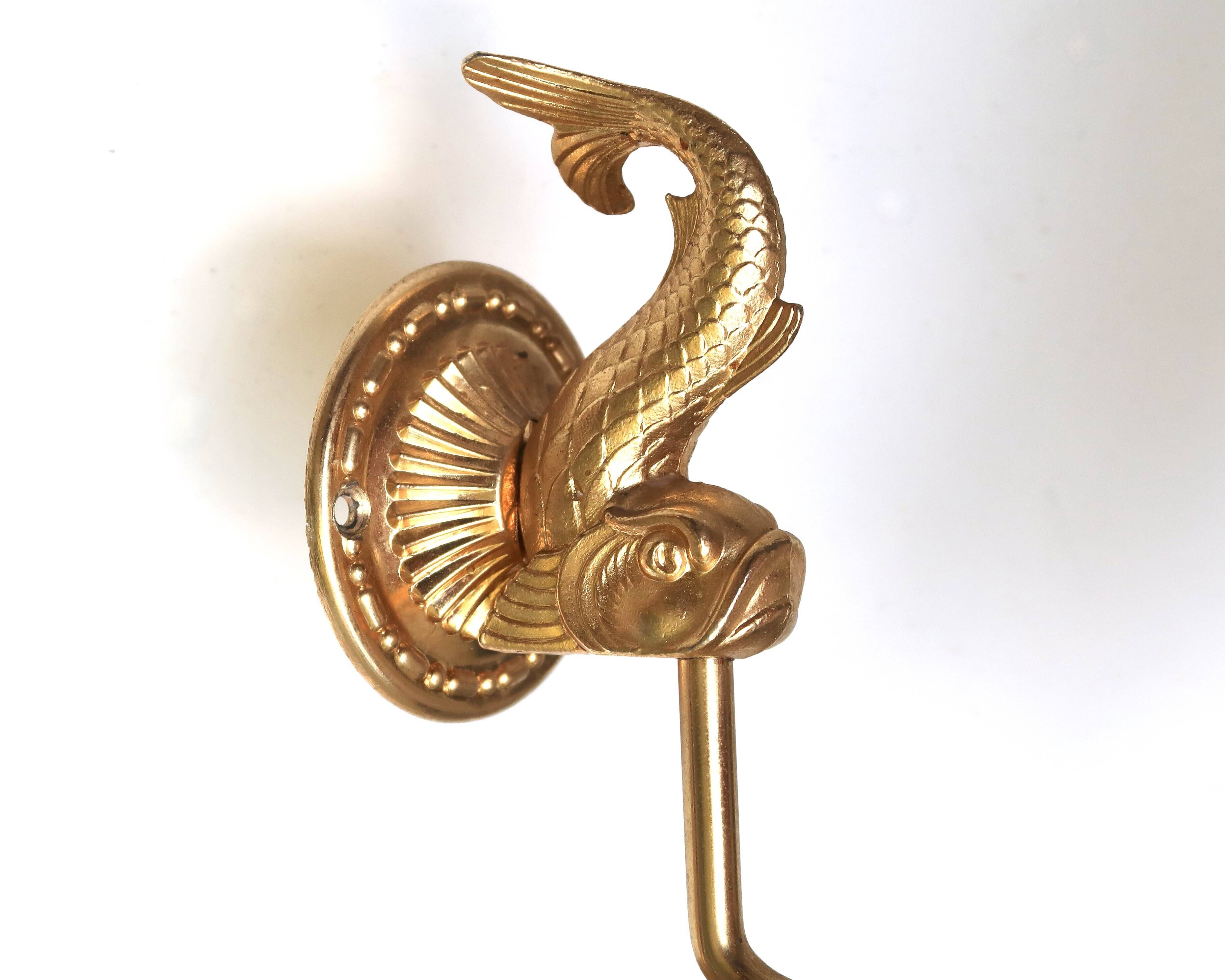 Wall shelf in gold metal and black glass adorned with fish.