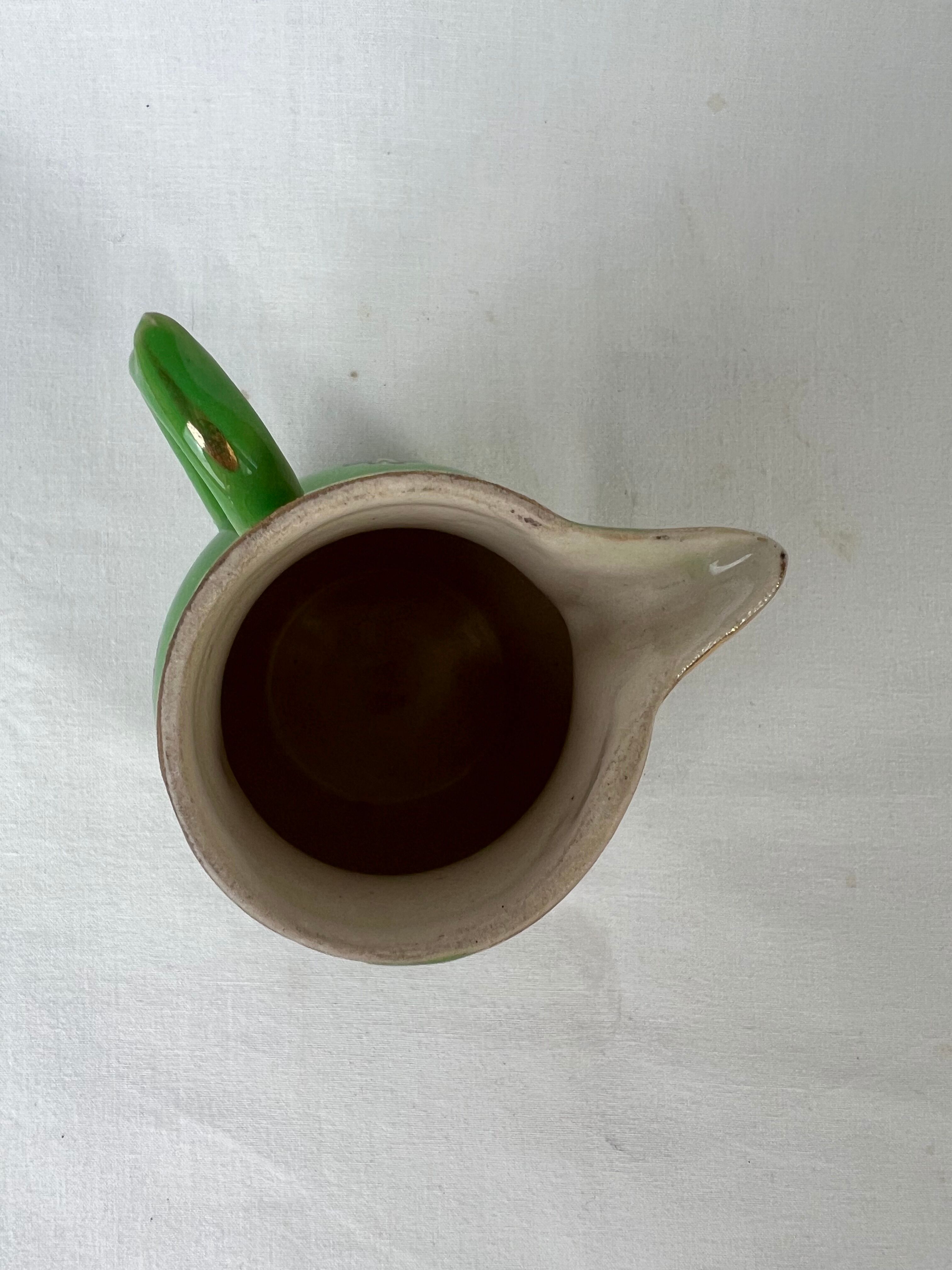 Green milk jug with enamelled flowers