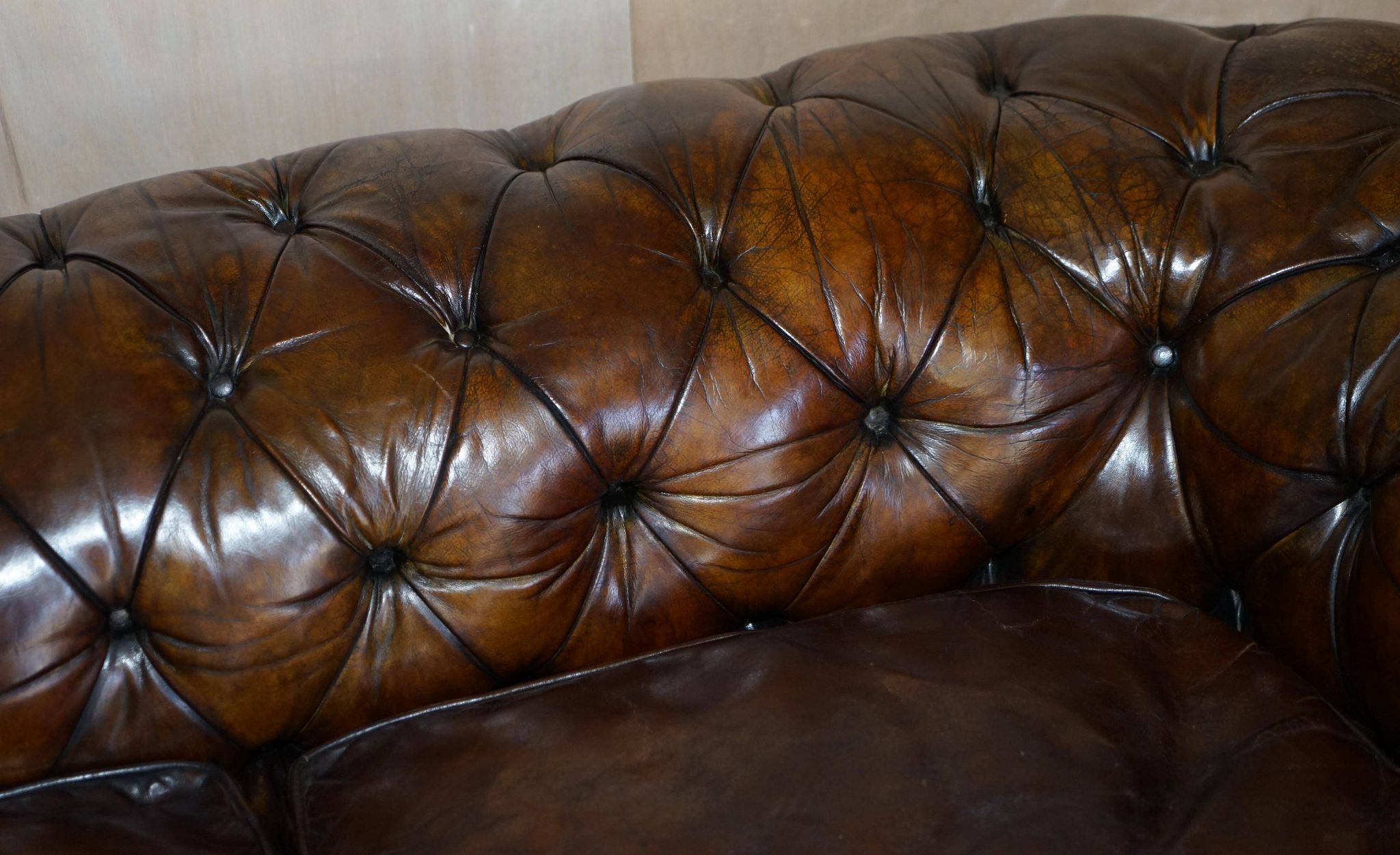 Victorian Chesterfield leather upholstered canapé with feather cushions.