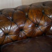 Victorian Chesterfield leather upholstered canapé with feather cushions.