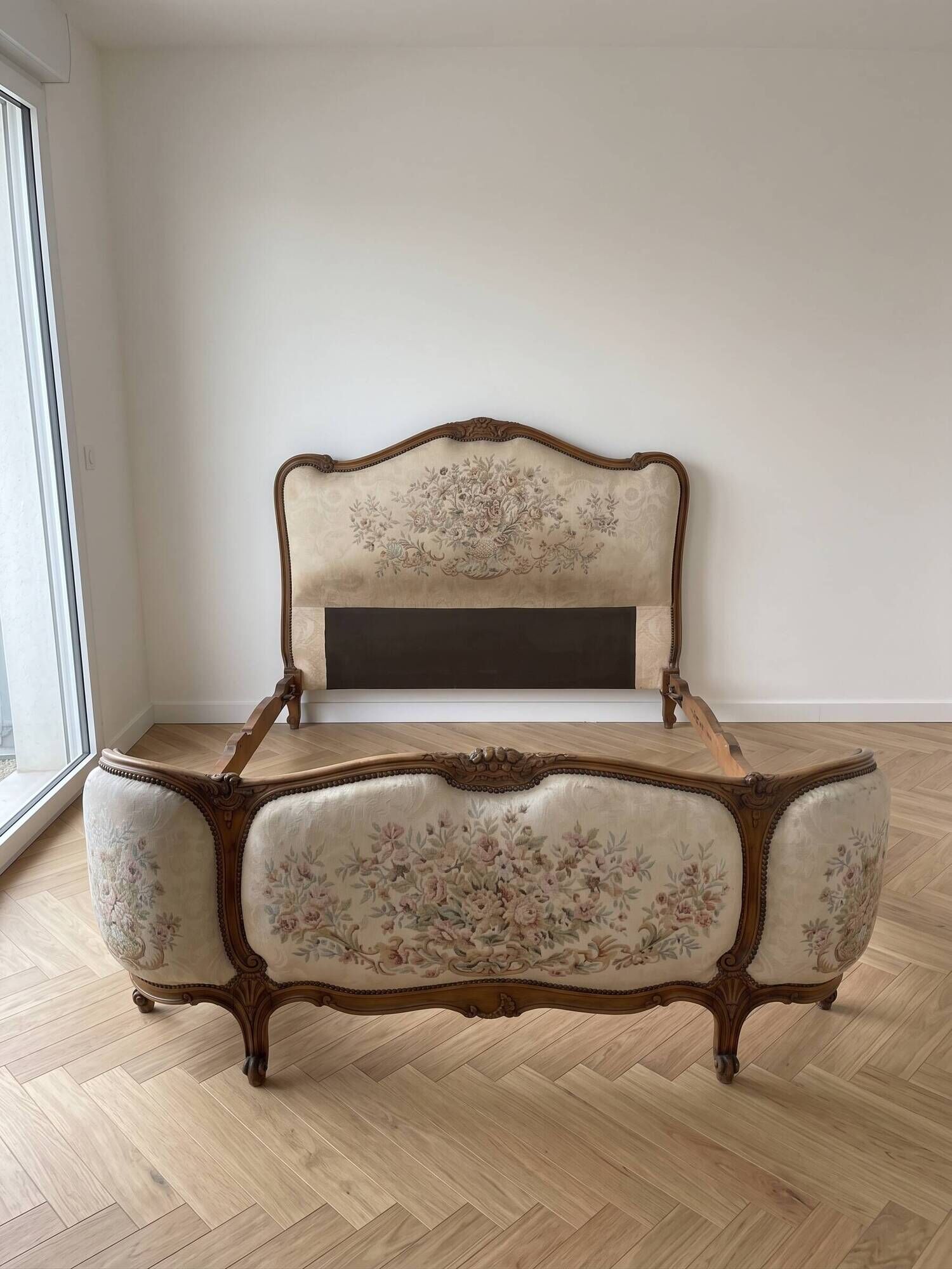 Double bed in Louis XVI style made of wood and floral fabric.