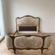 Double bed in Louis XVI style made of wood and floral fabric.