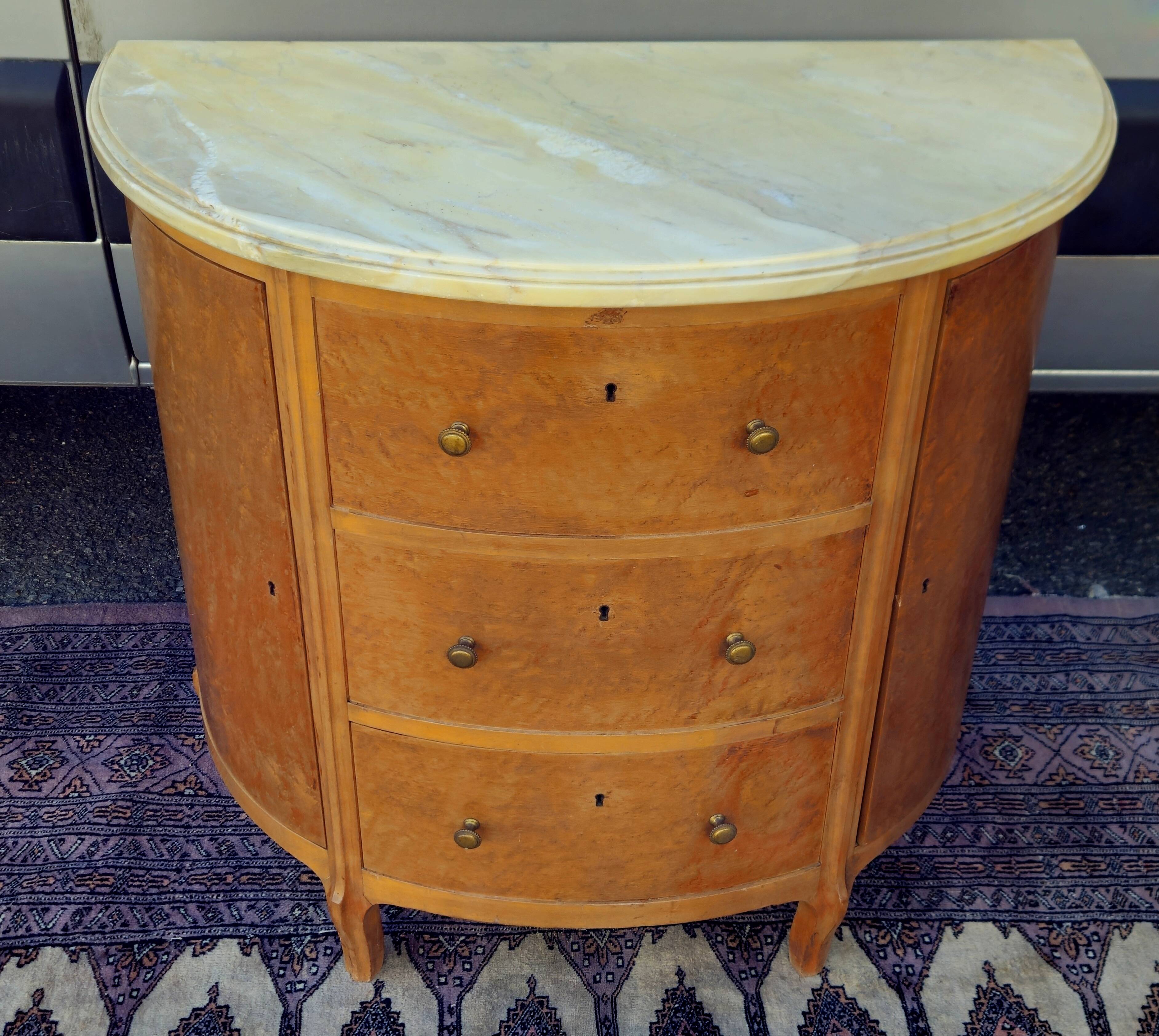 Half-moon commode in burl wood with a marble top.