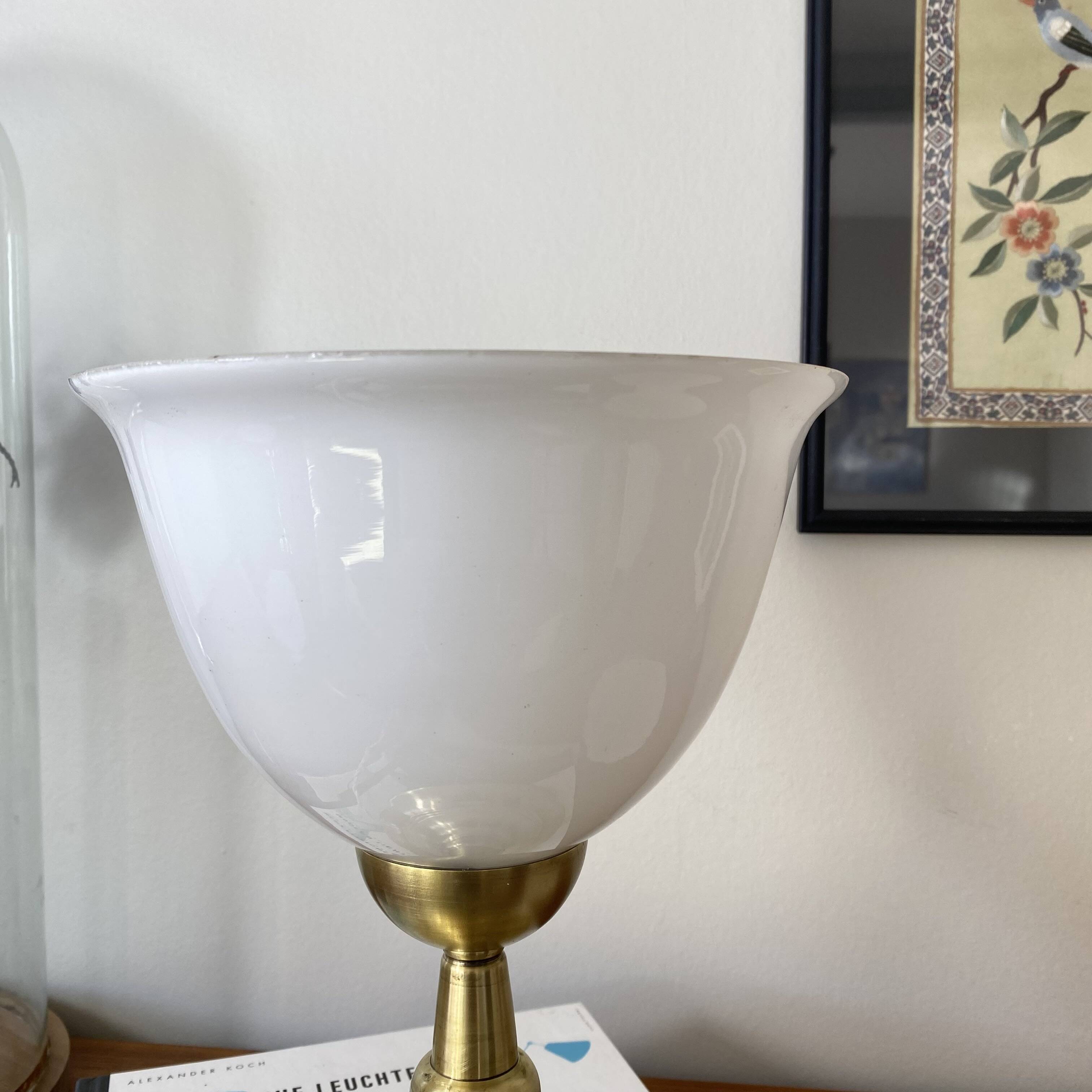 Antique white opaline glass globe table lamp with a brass base.