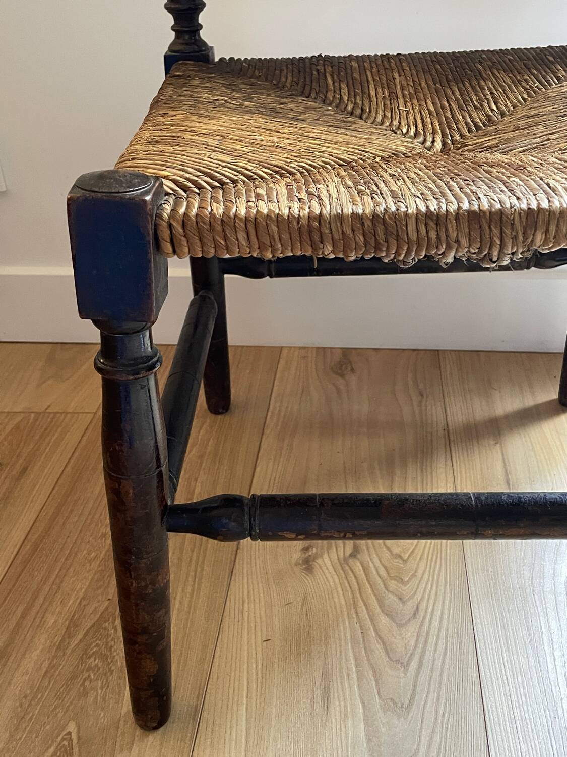 Corner chair made of turned wood with a straw seat.