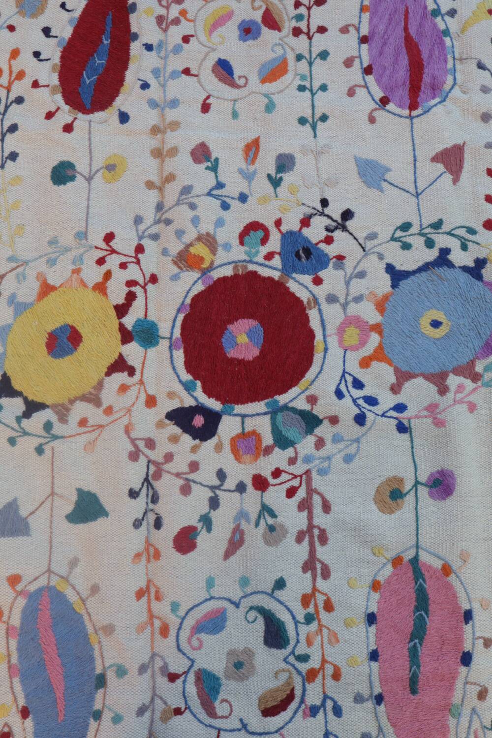White suzani kilim rug with hand embroidered multi-colored patterns