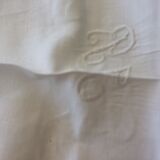 Old white tablecloth in thread with tangles of embroidered days central monogram