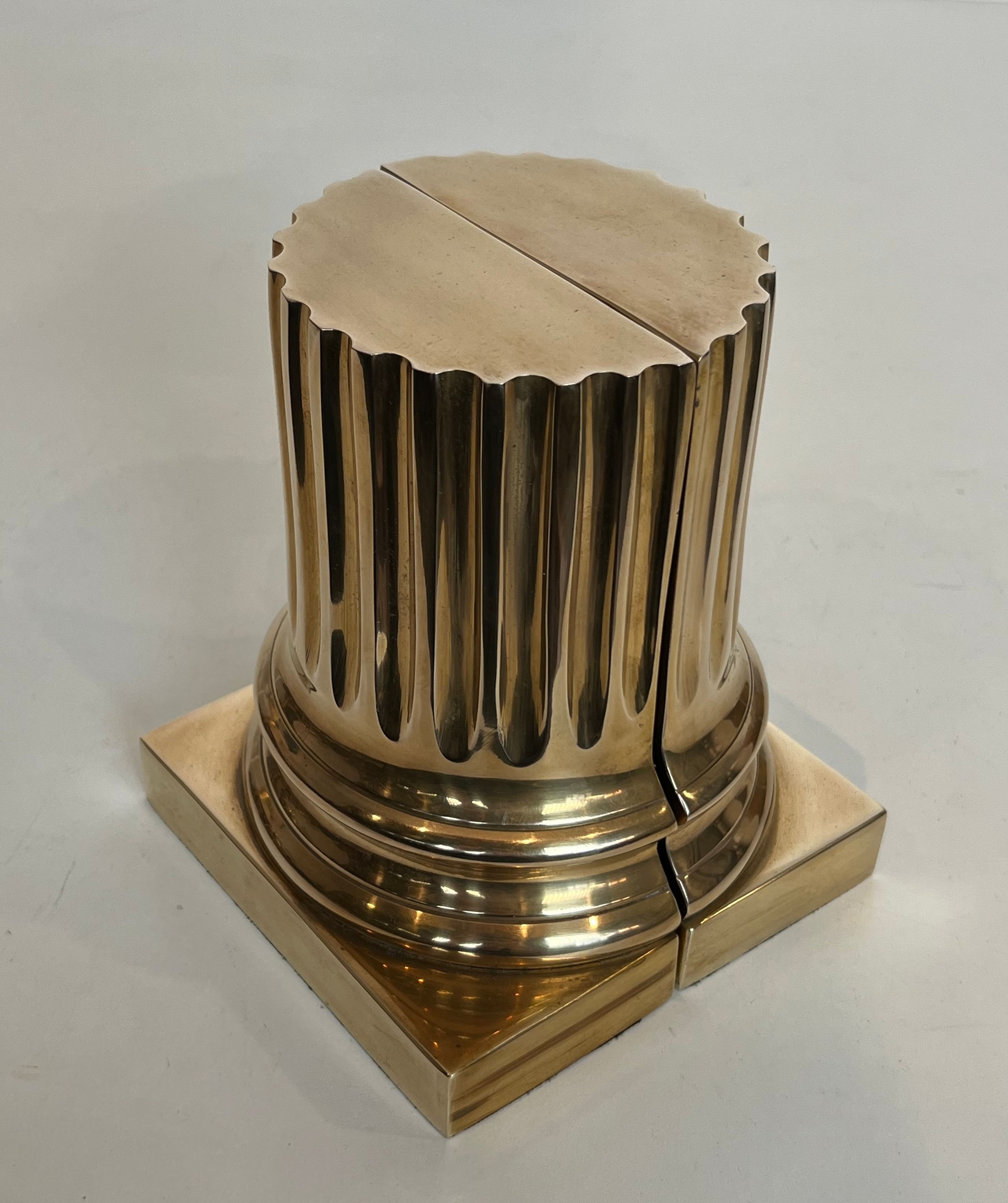 A pair of brass bookends representing columns.