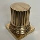 A pair of brass bookends representing columns.