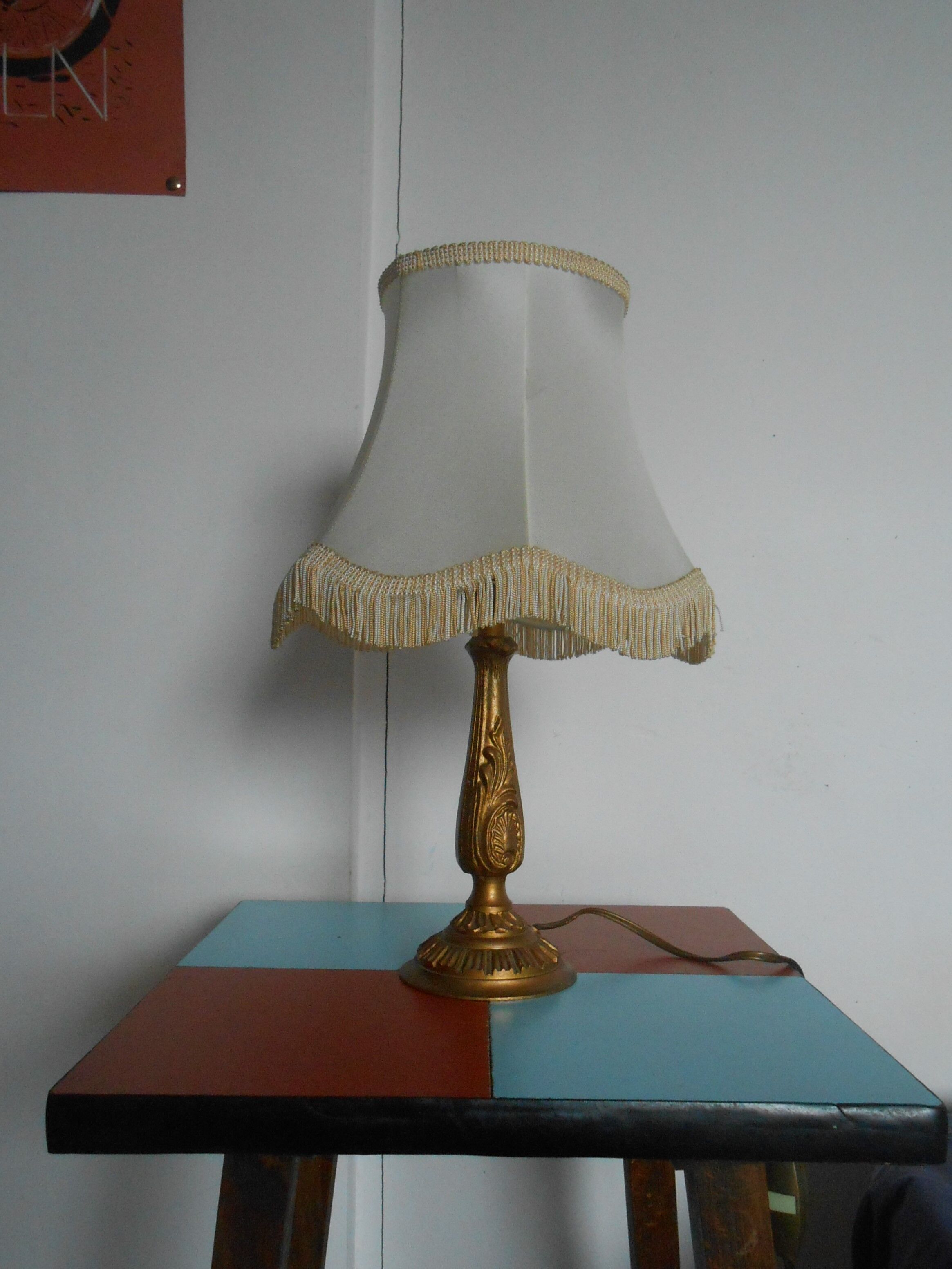 Lamp with brass foot and fringed lampshade