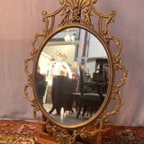 Miroir ovale en laiton doré , figures de chérubins et moulures