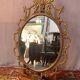 Oval mirror in gilded brass, figures of cherubs and moldings