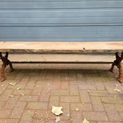 French country-style cast iron garden bench with old barn wood plank.