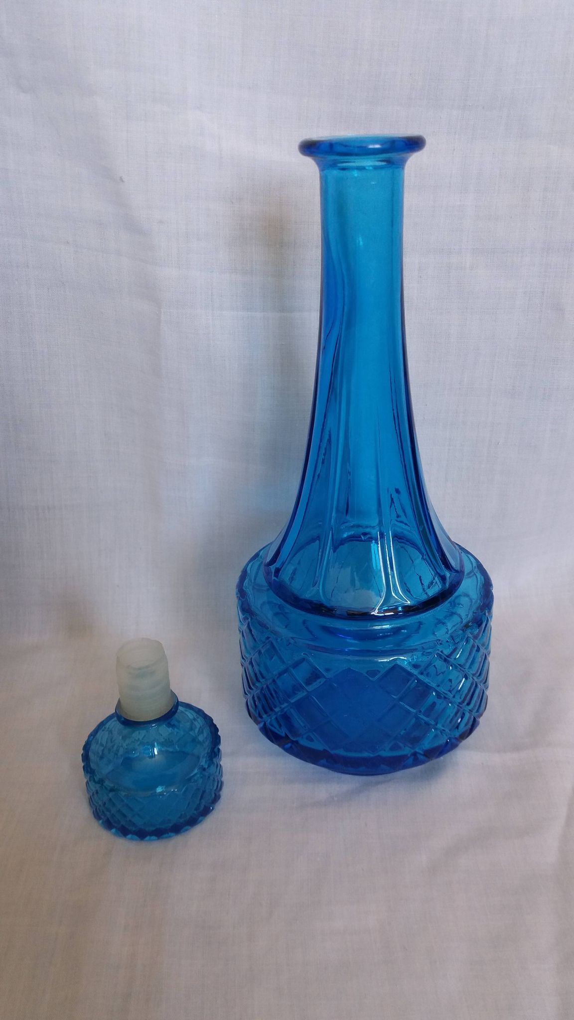 Turquoise glass carafe bottle with a stopper.