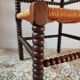 Old wooden turned spindle fireside chair with a straw seat.