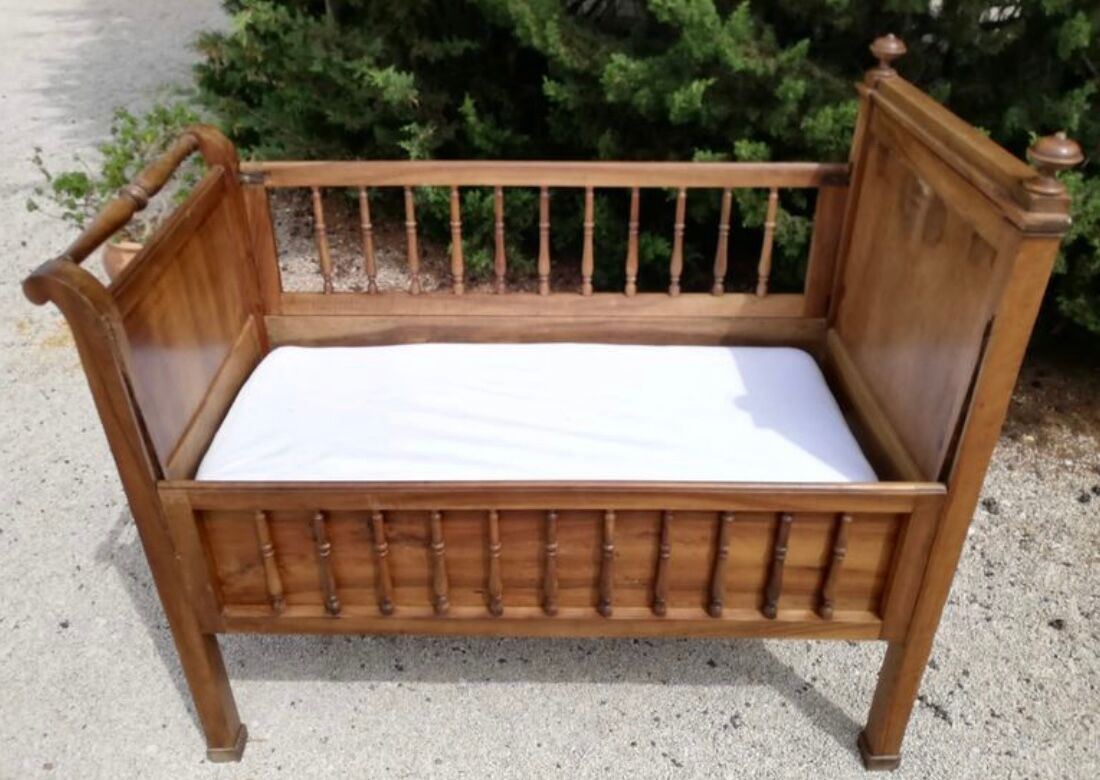 Old children's bed with retractable walnut bars