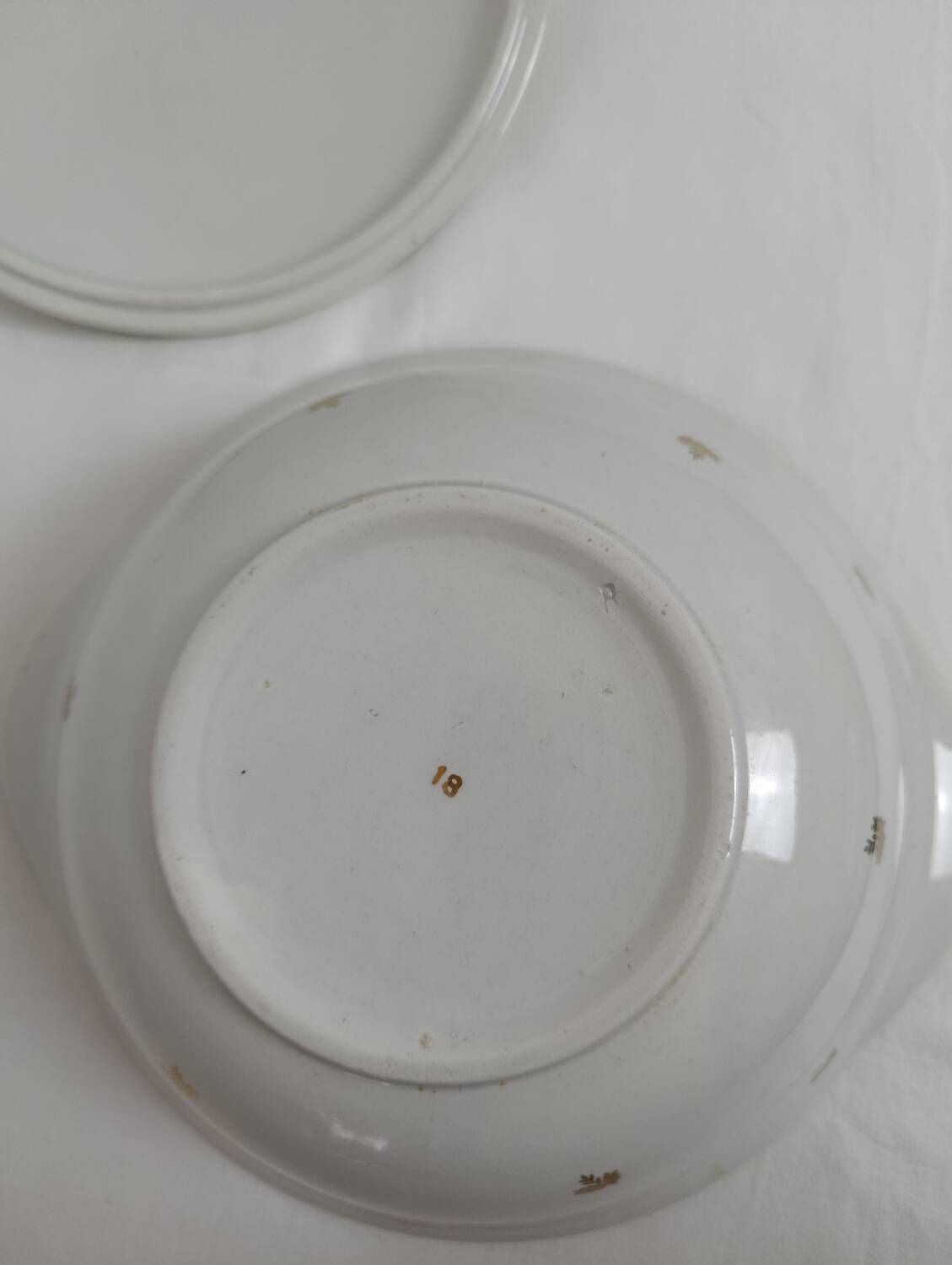 White earthenware soup tureen with a golden pattern.