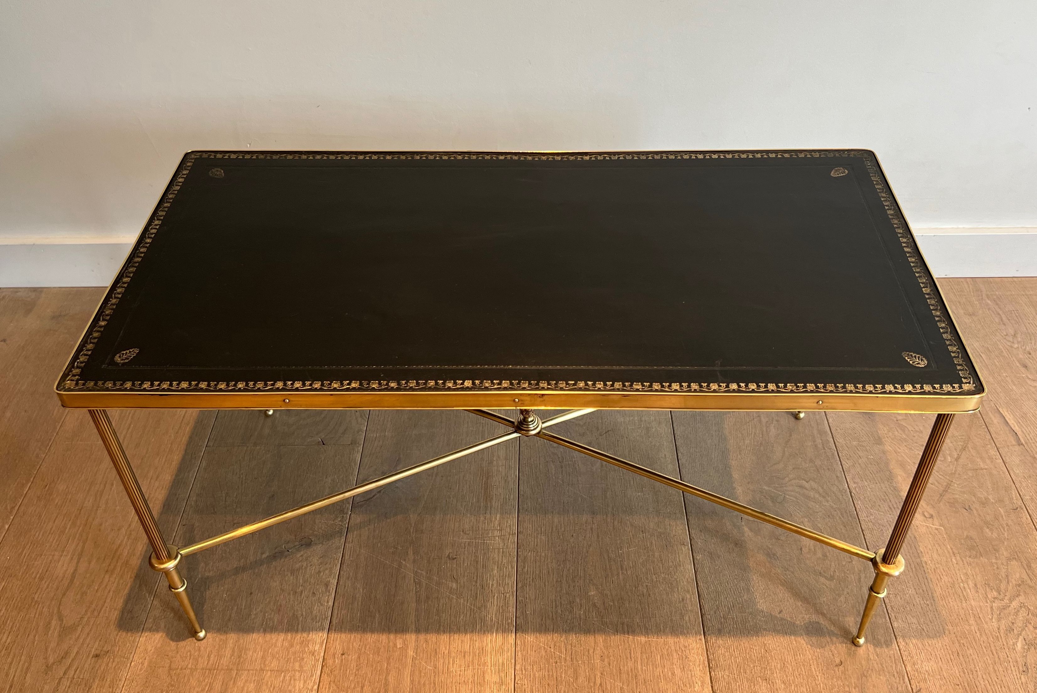Neoclassical brass coffee table with a black leather top and golden borders from Maison Jansen.