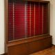 Large vintage display cabinet in wood and glass – red background, 15 shelves