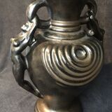 Black ceramic vase caught in naked women's bodies