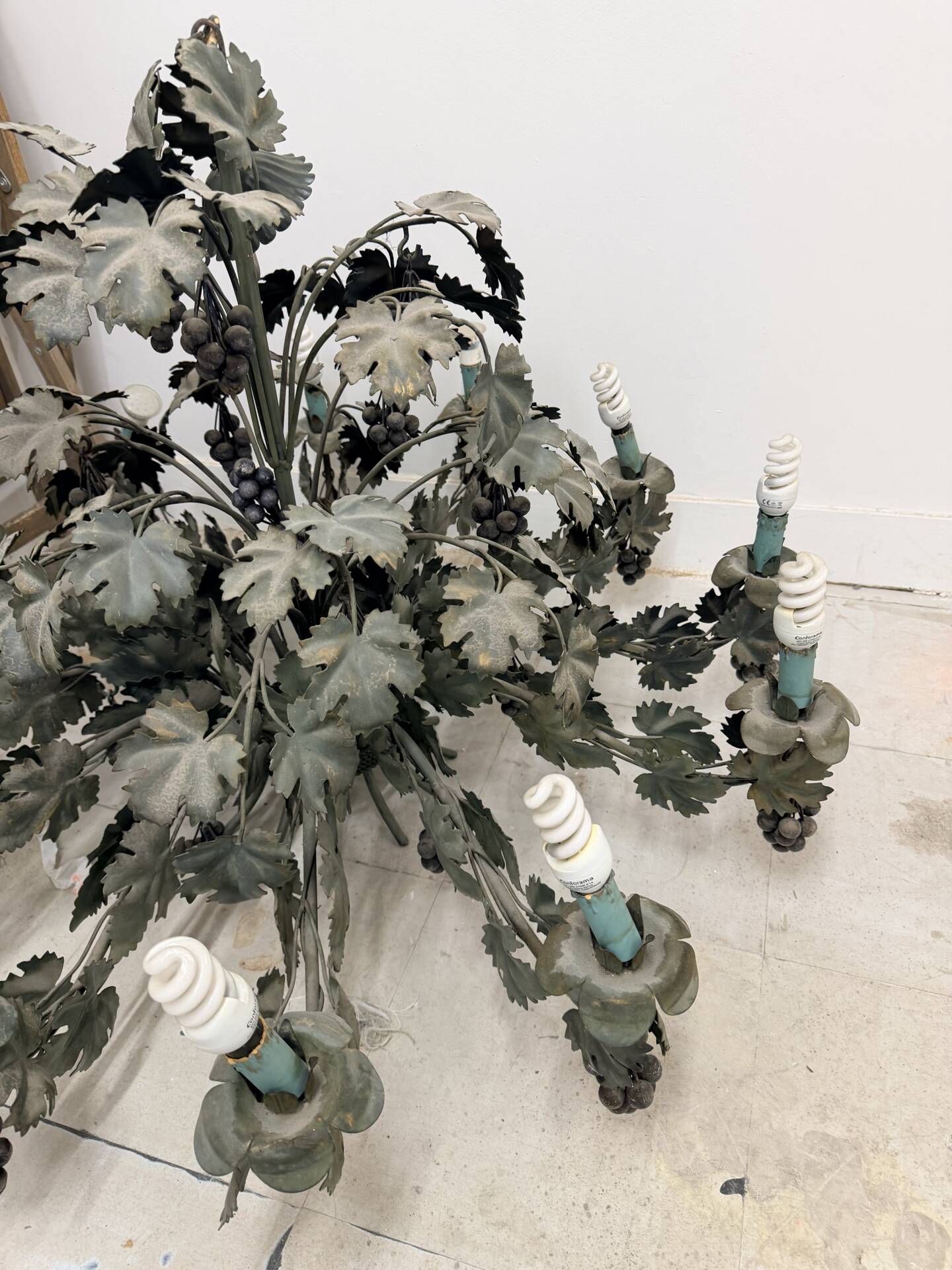 Old-fashioned country-style chandelier with virgin vine and bunch of grapes.