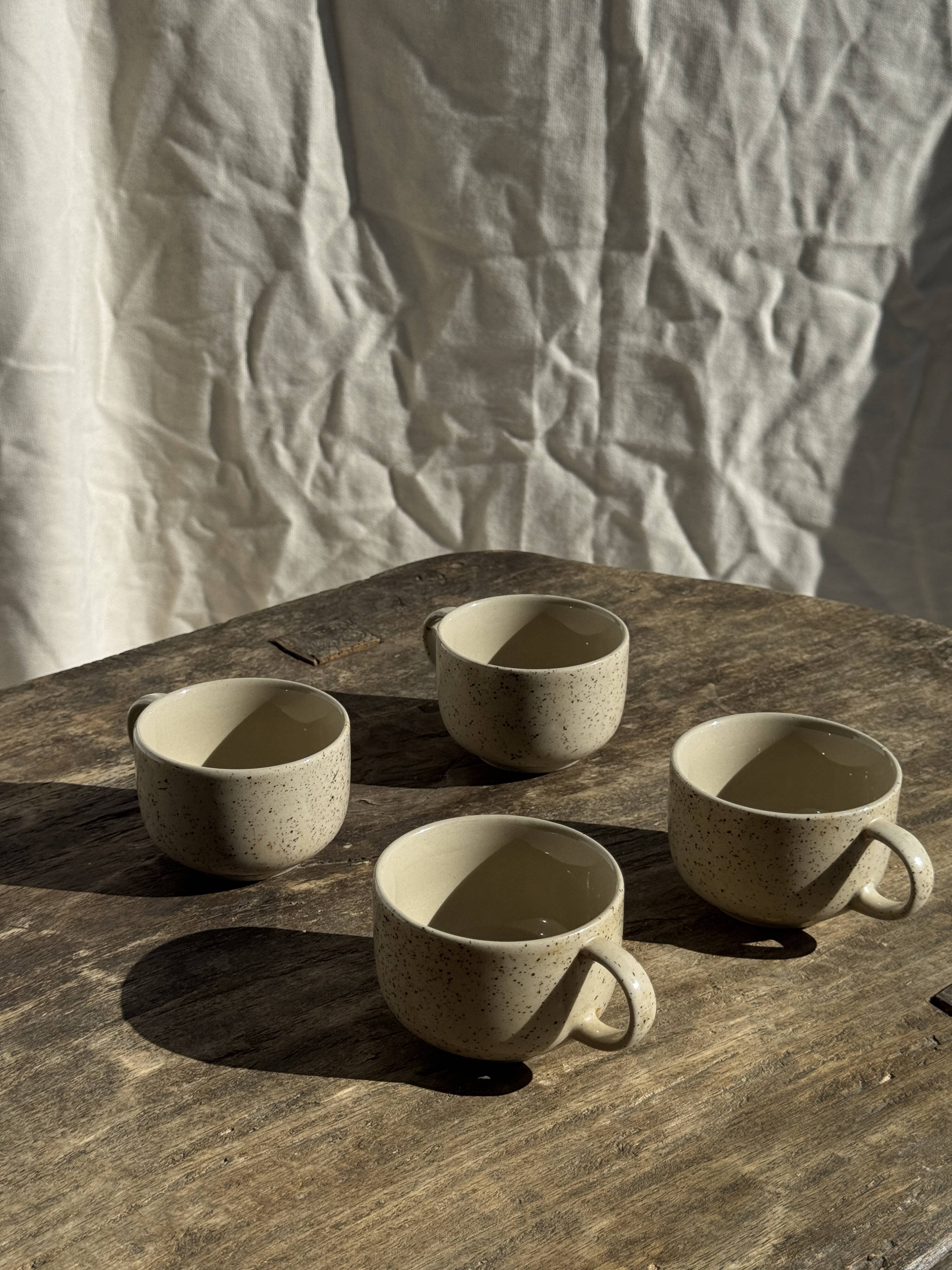 Set of 4 vintage speckled beige stoneware coffee cups.