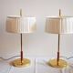 Paire de lampes de bureau suédoises en laiton avec des détails en cuir et des abat-jours blancs.