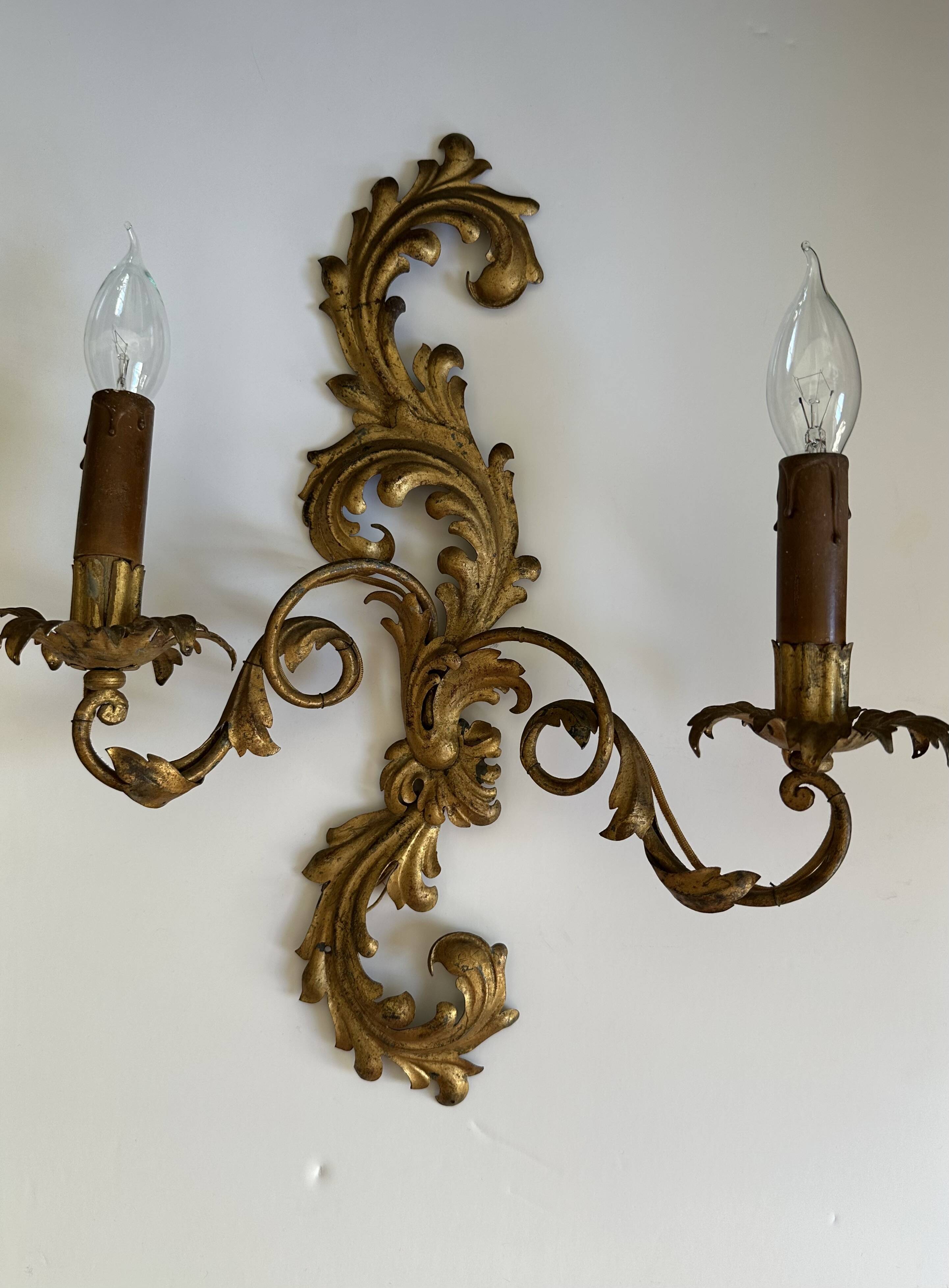 Pair of Italian Hollywood Regency wall lights in iron and gilded sheet metal.