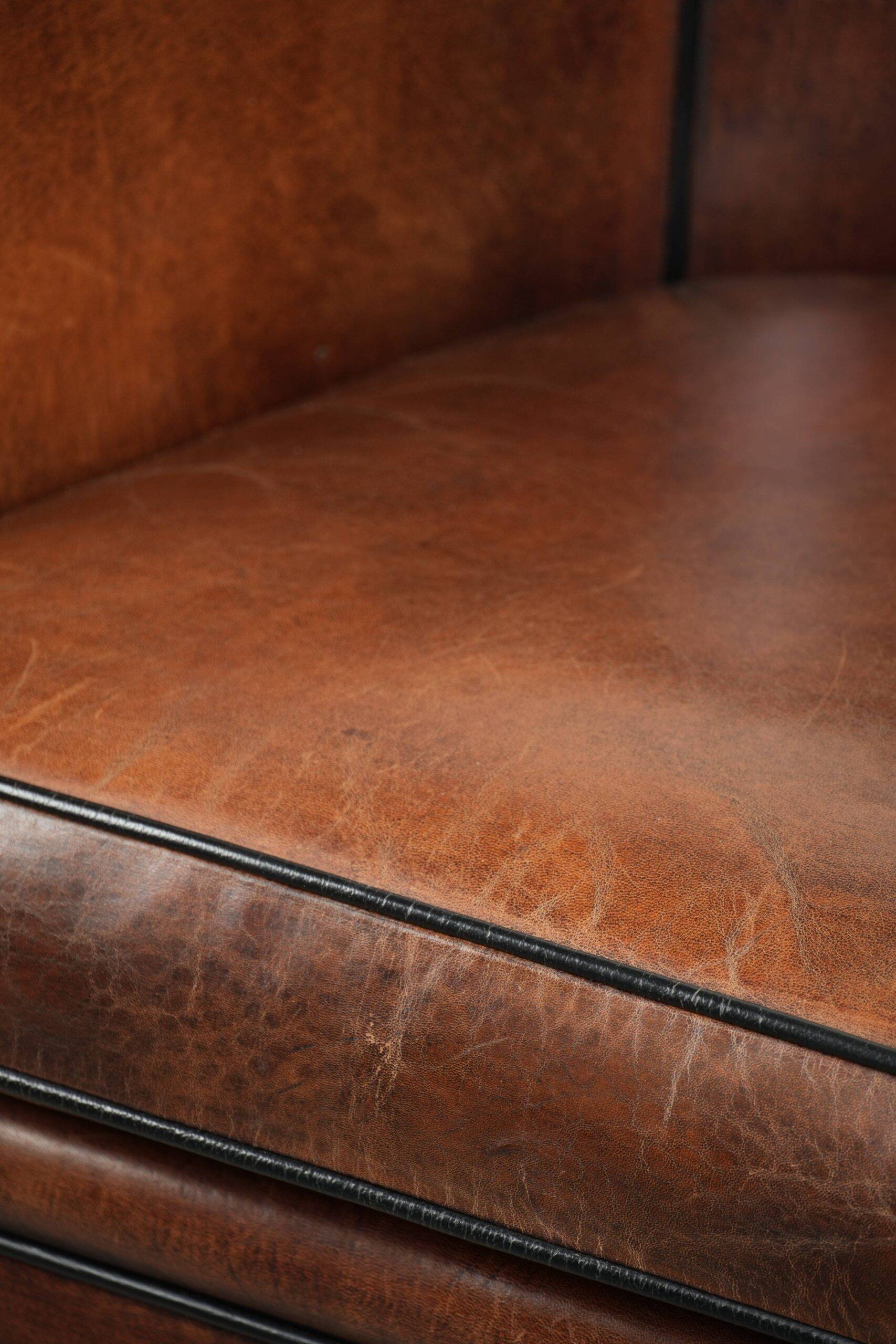 Sheepskin club armchair with deep warm colours and black piping