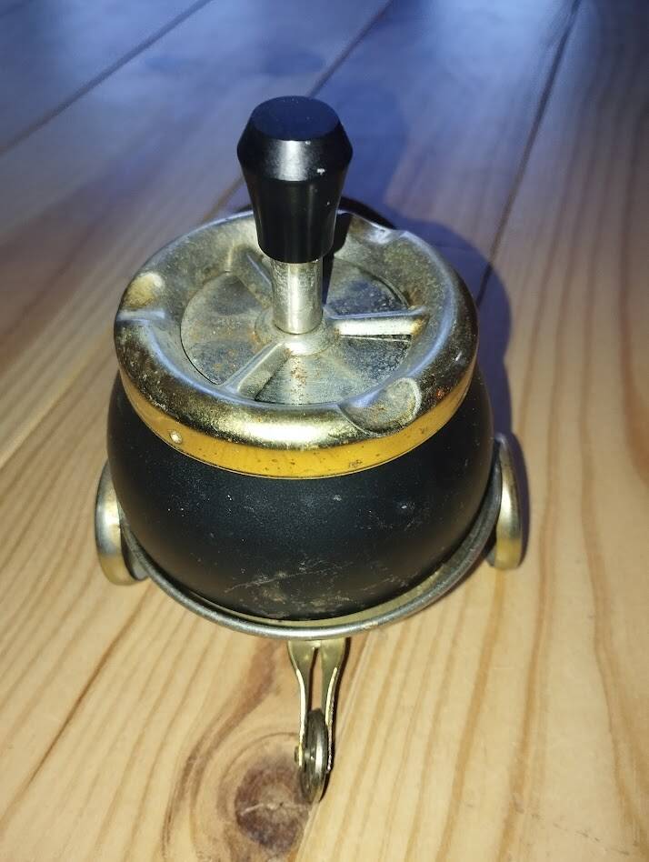 Original vintage ashtray on a small wheeled stand.