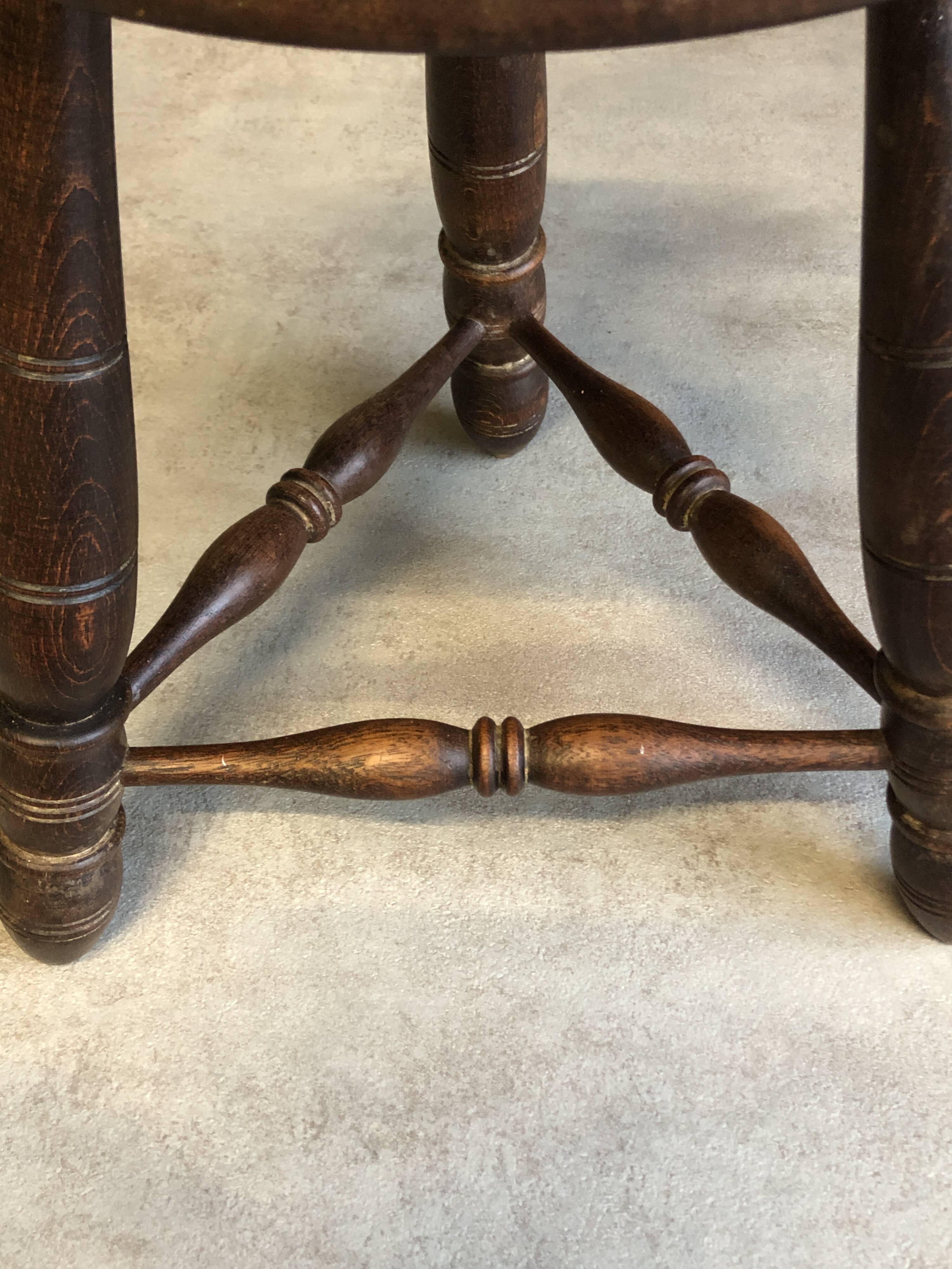 Round tripod stool in dark wood