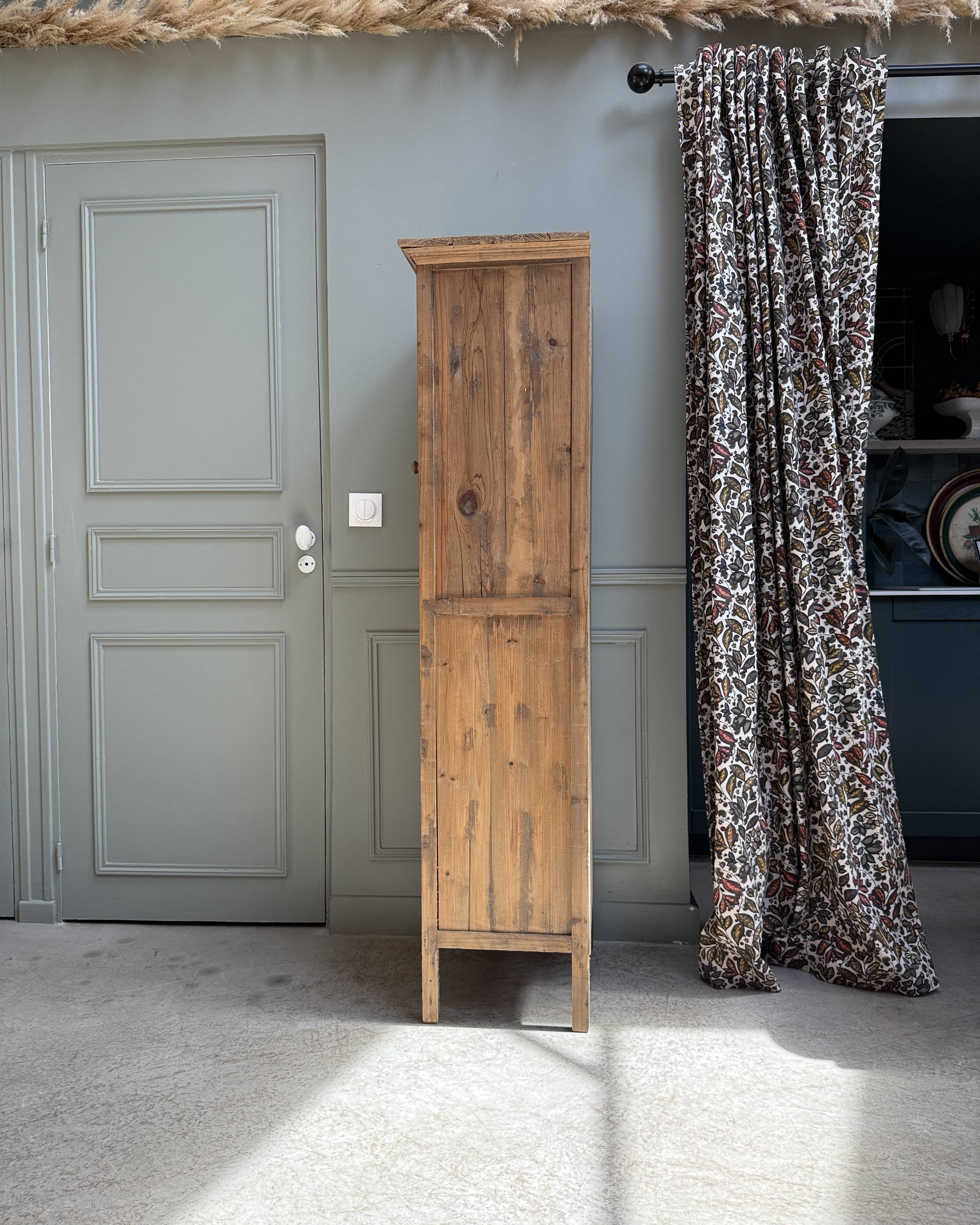 Column storage unit with a sculpted metal door.