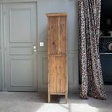 Column storage unit with a sculpted metal door.