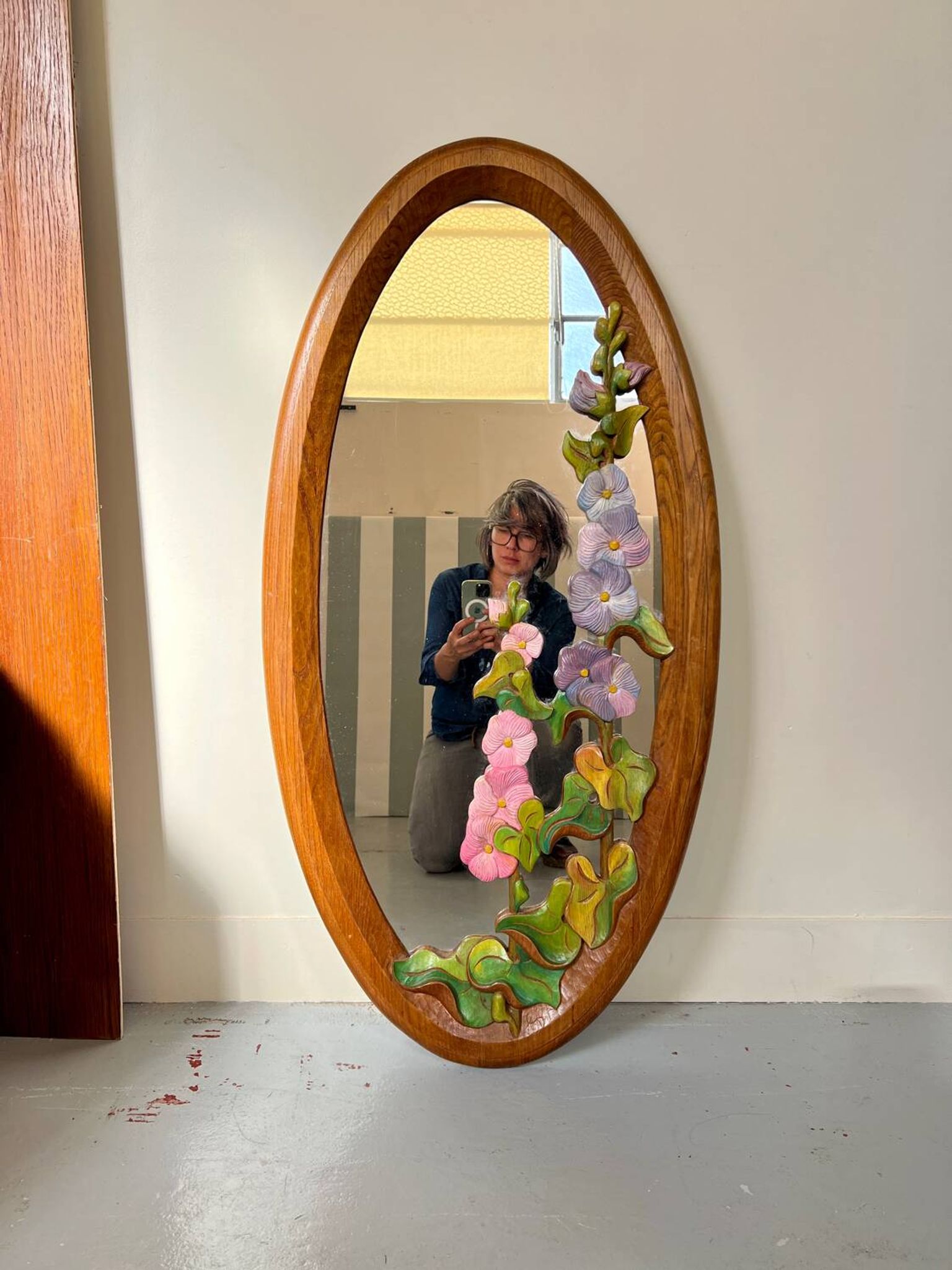 Carved wooden mirror with flower decorations.