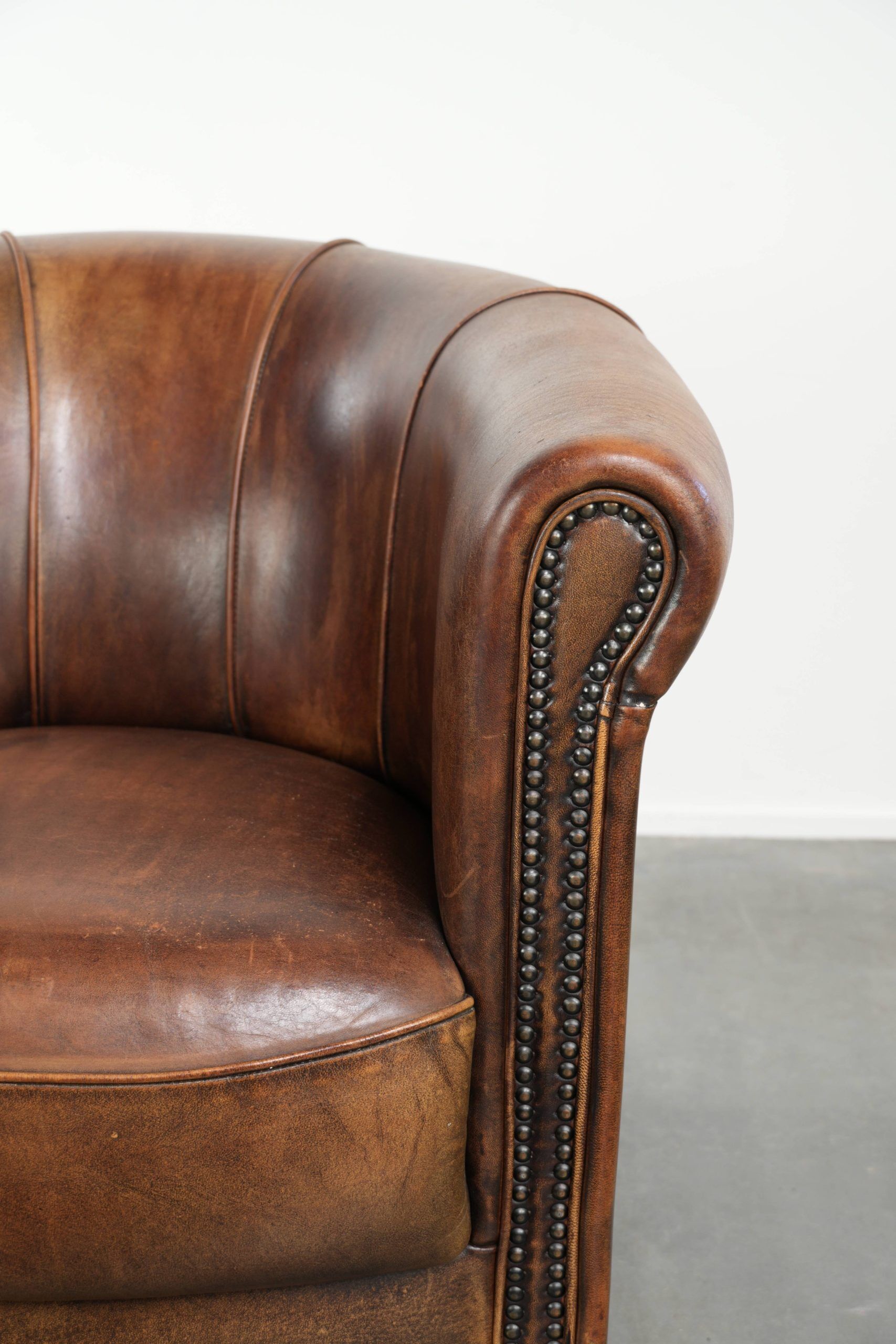 Sheepskin clubarmchair with beautiful patina finished with decorative nails