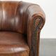 Sheepskin clubarmchair with beautiful patina finished with decorative nails