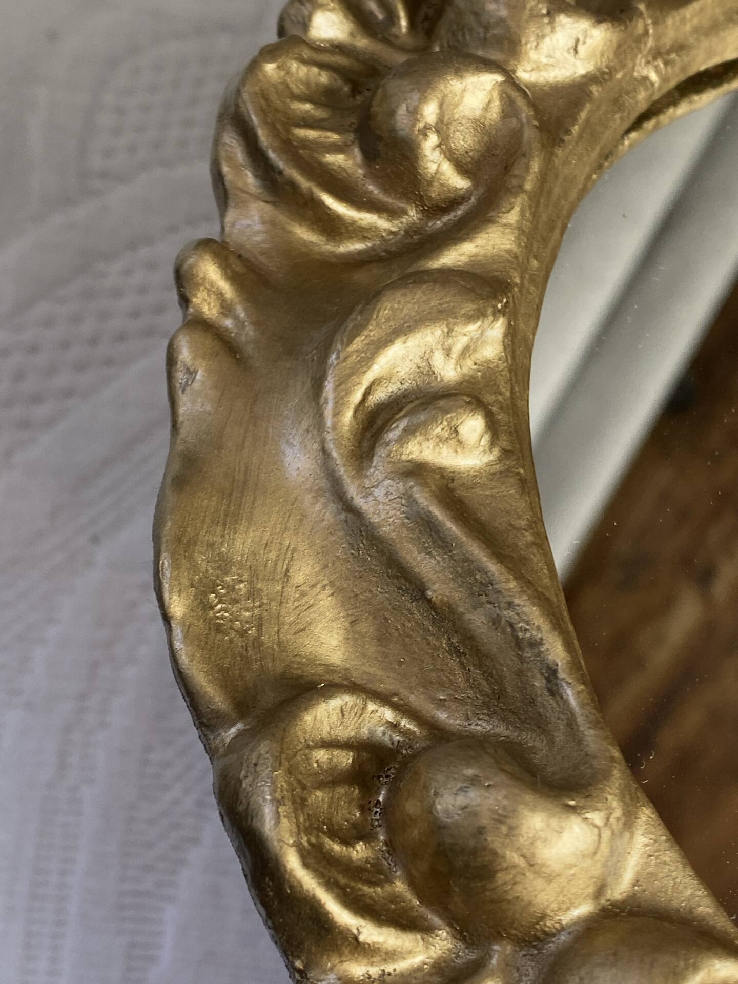 Round wooden mirror in golden colour.